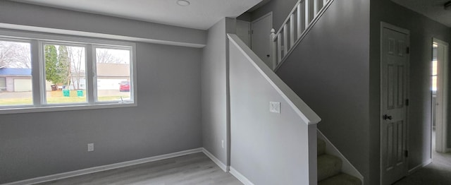 stairs featuring wood finished floors and baseboards