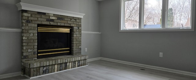 details with a fireplace, baseboards, and wood finished floors