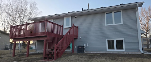 rear view of property featuring stairs, central AC unit, a lawn, and a deck