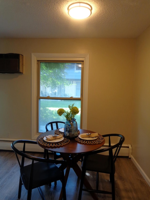 dining area featuring a wall mounted air conditioner, dark hardwood / wood-style floors, and a textured ceiling