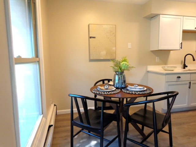 dining room with sink, dark wood-type flooring, and a baseboard radiator