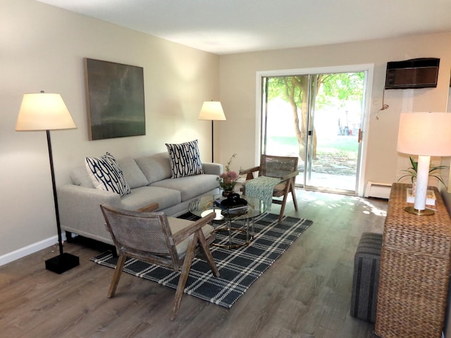 living room featuring baseboard heating, hardwood / wood-style floors, and a wall unit AC