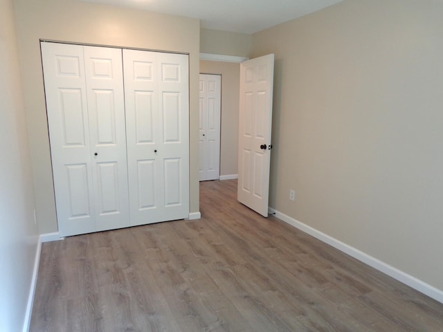 unfurnished bedroom featuring a closet and light hardwood / wood-style floors