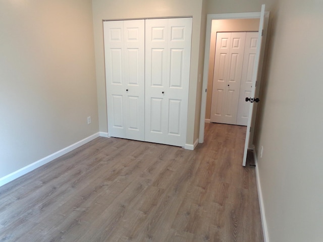 unfurnished bedroom with light hardwood / wood-style flooring and a closet