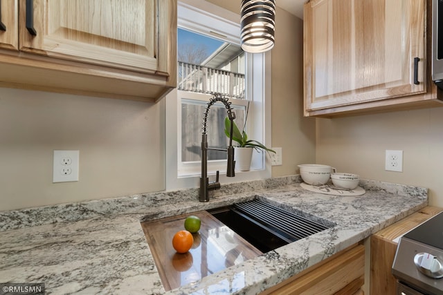 details with sink, light stone counters, and light brown cabinetry