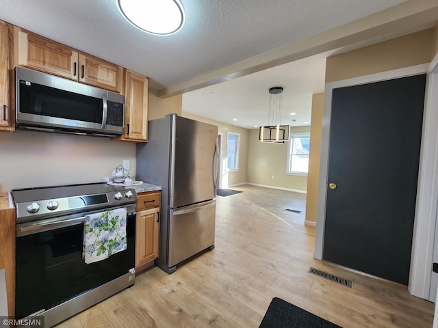 kitchen with decorative light fixtures, stainless steel appliances, and light hardwood / wood-style floors