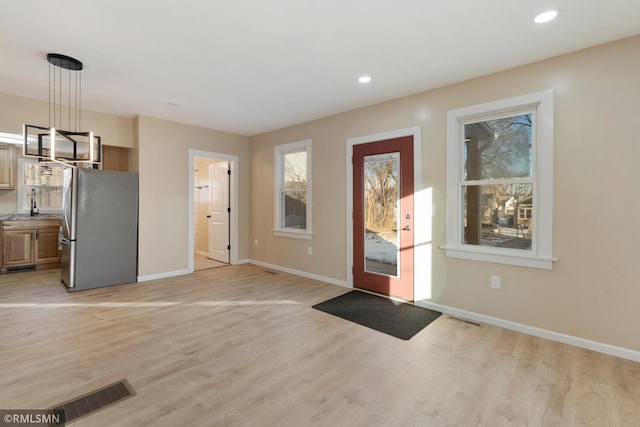 foyer entrance featuring sink and light hardwood / wood-style flooring