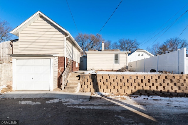 view of snow covered exterior featuring a garage