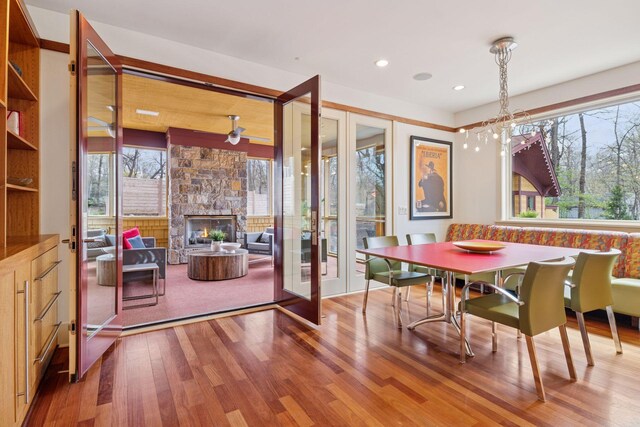 dining space with recessed lighting, french doors, wood finished floors, and a fireplace