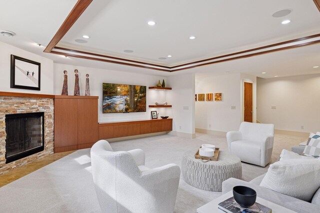 living room with a raised ceiling, a fireplace, recessed lighting, and light colored carpet