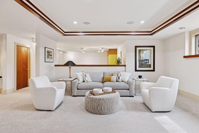carpeted living room with baseboards, recessed lighting, a raised ceiling, and ornamental molding