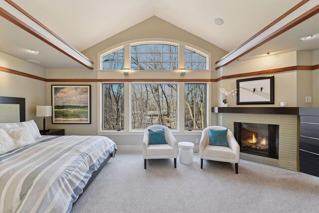 carpeted bedroom featuring a fireplace, lofted ceiling, and multiple windows