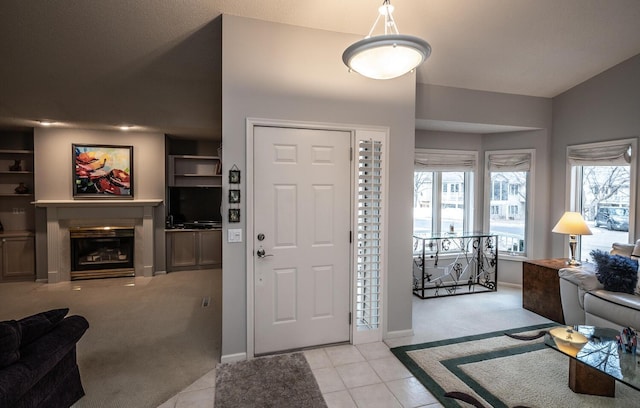 carpeted entryway featuring vaulted ceiling