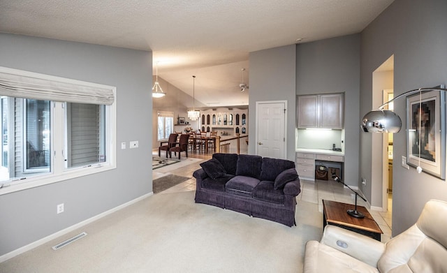 living room featuring light carpet, built in desk, and vaulted ceiling