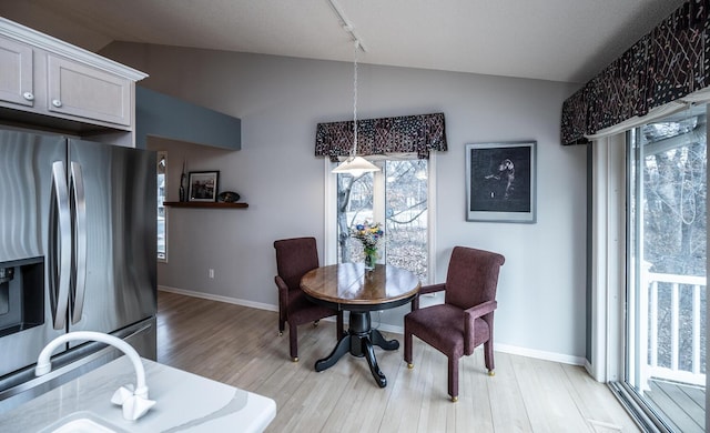 dining area with light hardwood / wood-style flooring and lofted ceiling