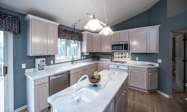 kitchen with vaulted ceiling, sink, decorative light fixtures, and appliances with stainless steel finishes