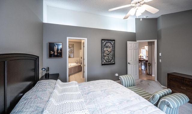 carpeted bedroom featuring ceiling fan, a textured ceiling, and ensuite bath