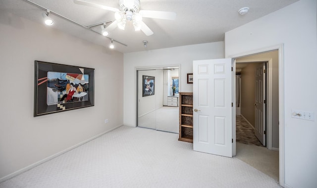 bedroom featuring a textured ceiling, ceiling fan, light carpet, and track lighting