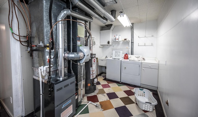 interior space with sink, gas water heater, heating unit, and washing machine and clothes dryer