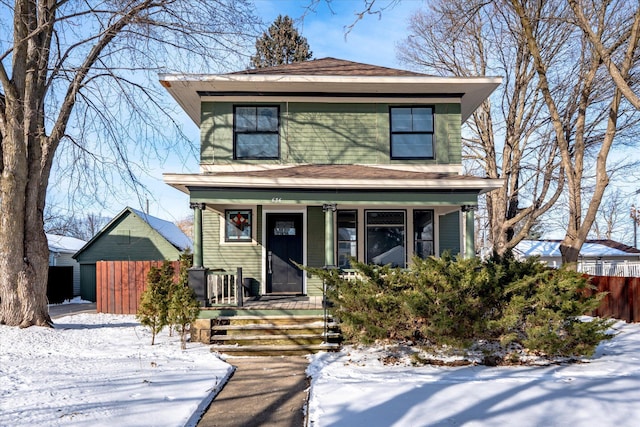 american foursquare style home with fence and a porch