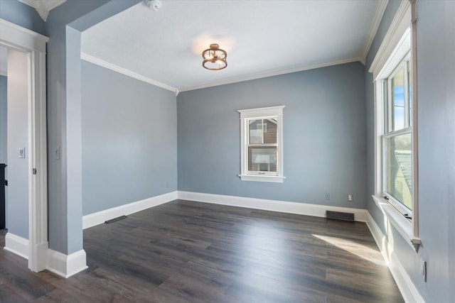 empty room with baseboards, visible vents, ornamental molding, and dark wood finished floors