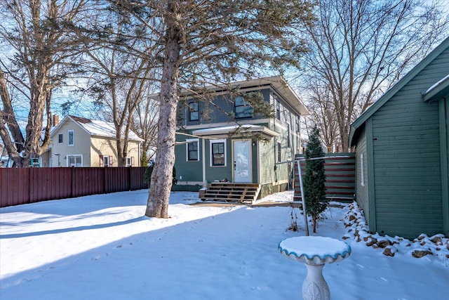 snow covered property featuring fence