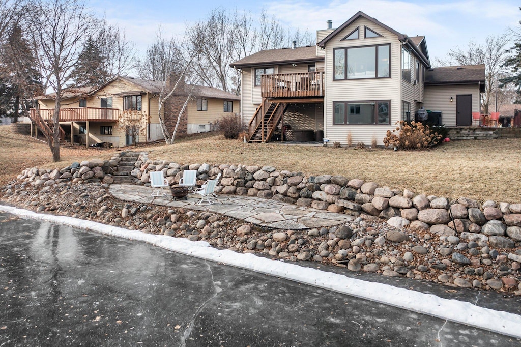 back of property with a patio, a deck, and a lawn