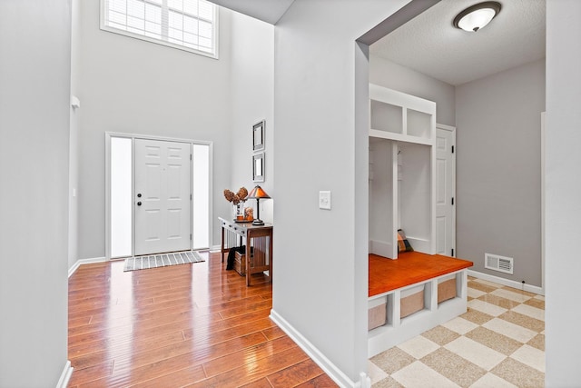 entrance foyer with light hardwood / wood-style flooring and a towering ceiling