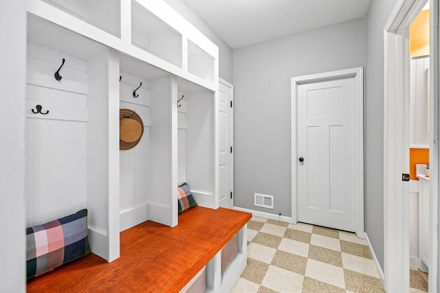 mudroom with a textured ceiling