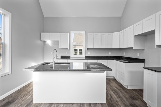 kitchen featuring white cabinets, sink, a healthy amount of sunlight, and an island with sink