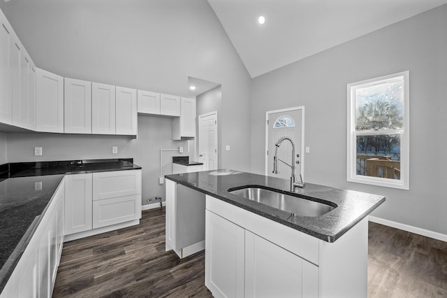 kitchen featuring sink, dark hardwood / wood-style floors, white cabinetry, and an island with sink