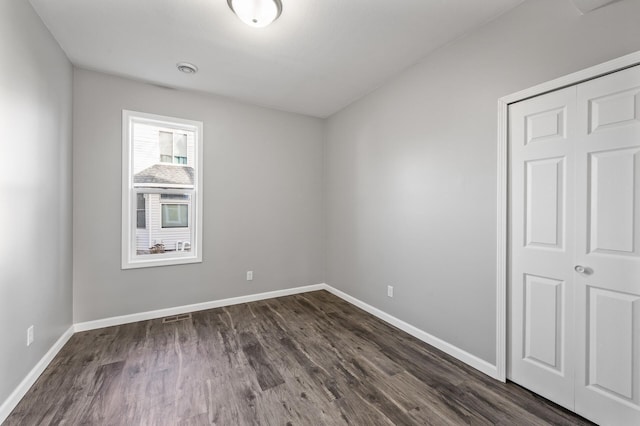 empty room with dark wood-type flooring