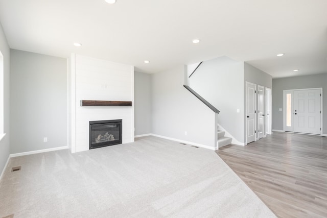 unfurnished living room with a fireplace and wood-type flooring