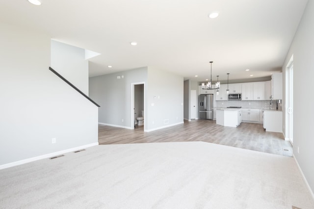 unfurnished living room featuring a notable chandelier