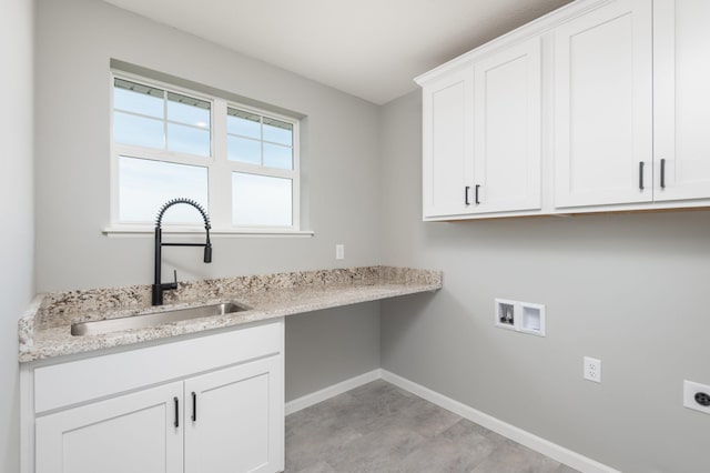 clothes washing area with hookup for a washing machine, sink, cabinets, and hookup for an electric dryer