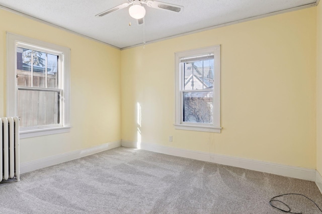 empty room with light carpet, radiator heating unit, ornamental molding, and plenty of natural light