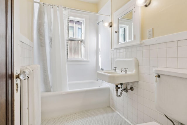 bathroom featuring shower / tub combo, radiator heating unit, tile patterned flooring, and tile walls