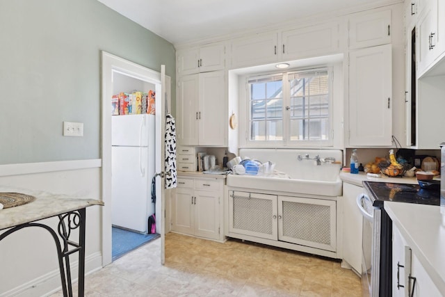 kitchen featuring electric stove, sink, white cabinets, and white refrigerator