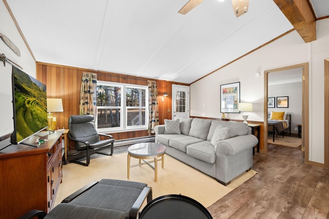 living room featuring ornamental molding, a baseboard heating unit, lofted ceiling with beams, hardwood / wood-style floors, and wood walls