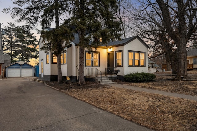 view of front of house featuring stucco siding, an outbuilding, and a garage