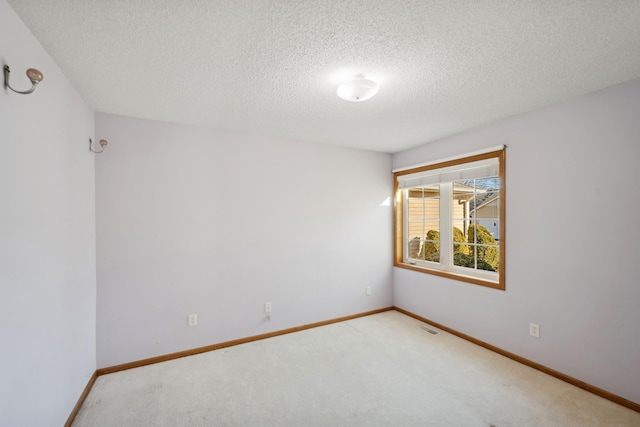 carpeted spare room with a textured ceiling