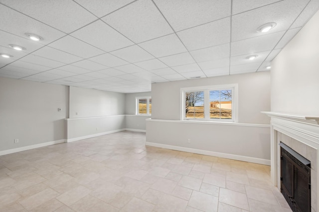 unfurnished living room featuring a paneled ceiling and a fireplace