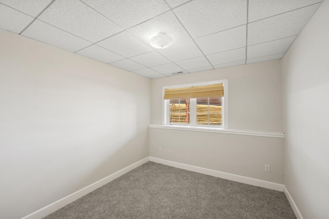 carpeted spare room featuring a paneled ceiling