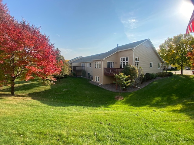 back of property featuring a yard and a wooden deck