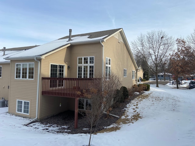 snow covered property featuring central AC and a wooden deck