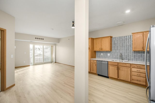 kitchen featuring tasteful backsplash, stainless steel appliances, light hardwood / wood-style floors, and sink