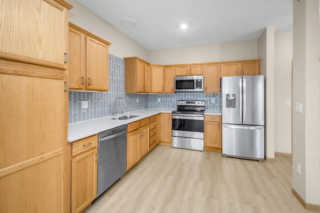 kitchen featuring sink, backsplash, stainless steel appliances, light hardwood / wood-style floors, and light brown cabinets