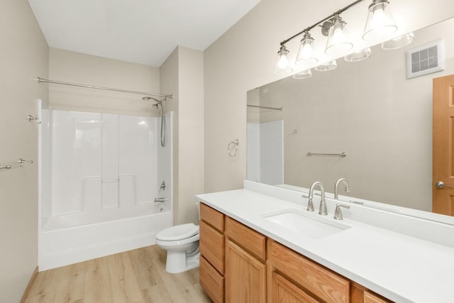 full bathroom featuring vanity, hardwood / wood-style flooring, bathing tub / shower combination, and toilet