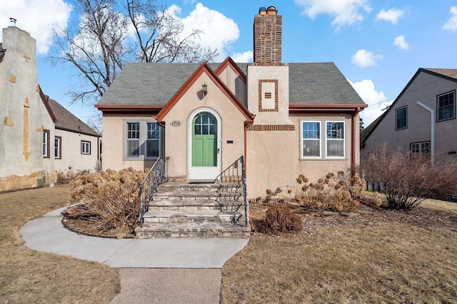 view of front of home with stucco siding and a chimney