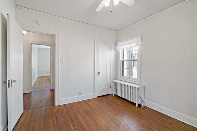 unfurnished bedroom with crown molding, radiator, dark wood-style floors, and ceiling fan